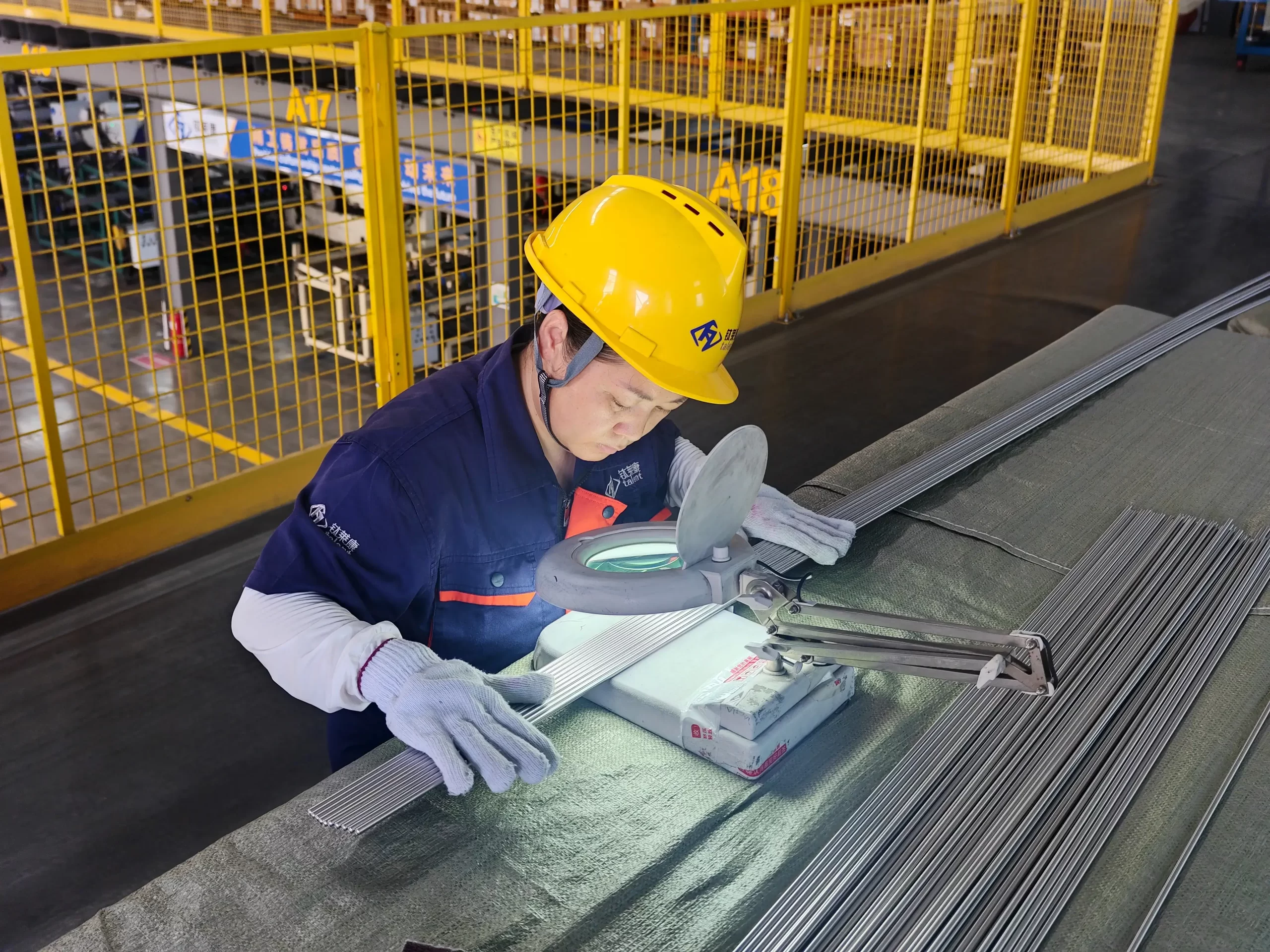 Chinese engineer inspecting custom titanium parts and technical drawings